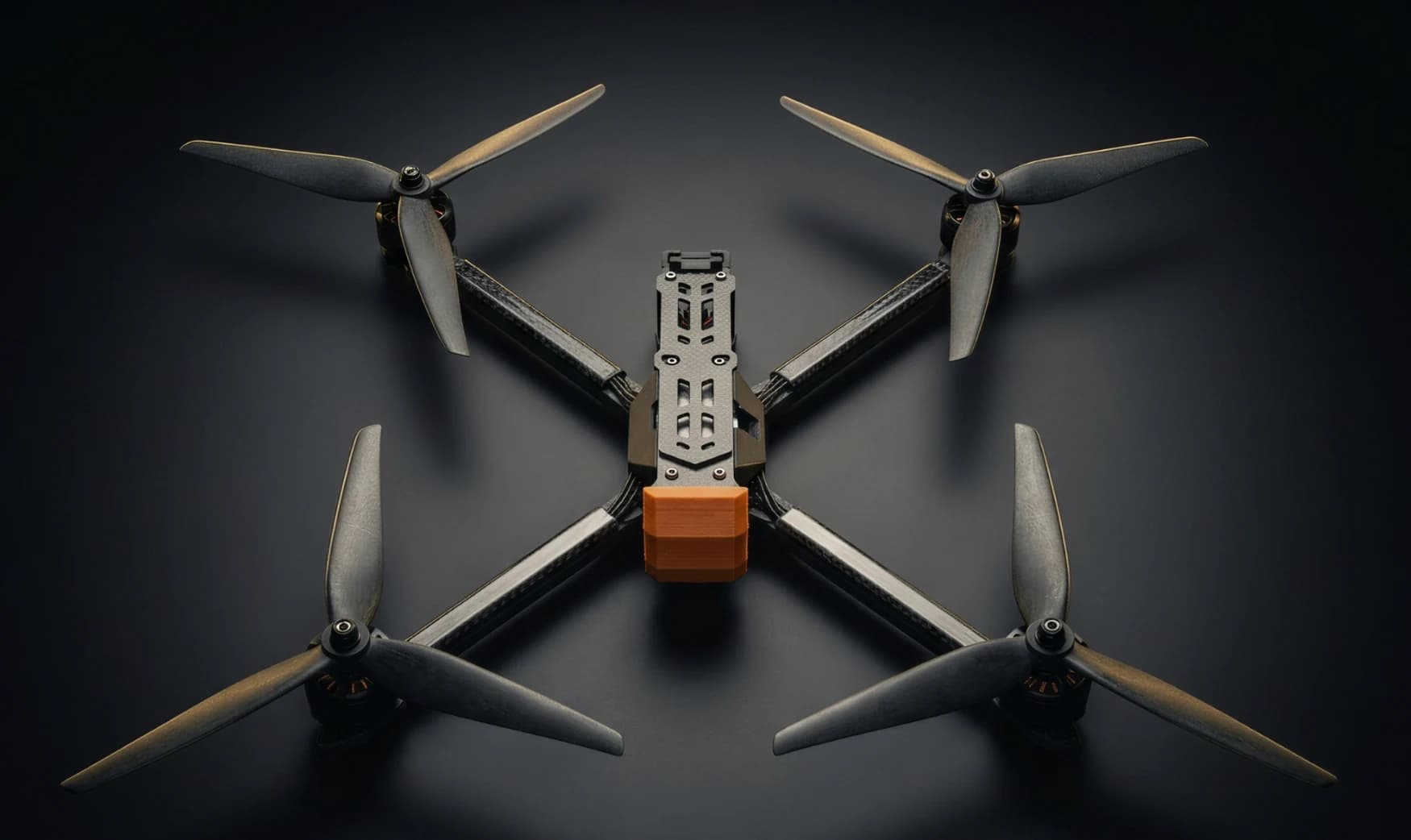 Unmanned Industries T100 FPV targeting and training airframe, top-down studio shot on a dark background