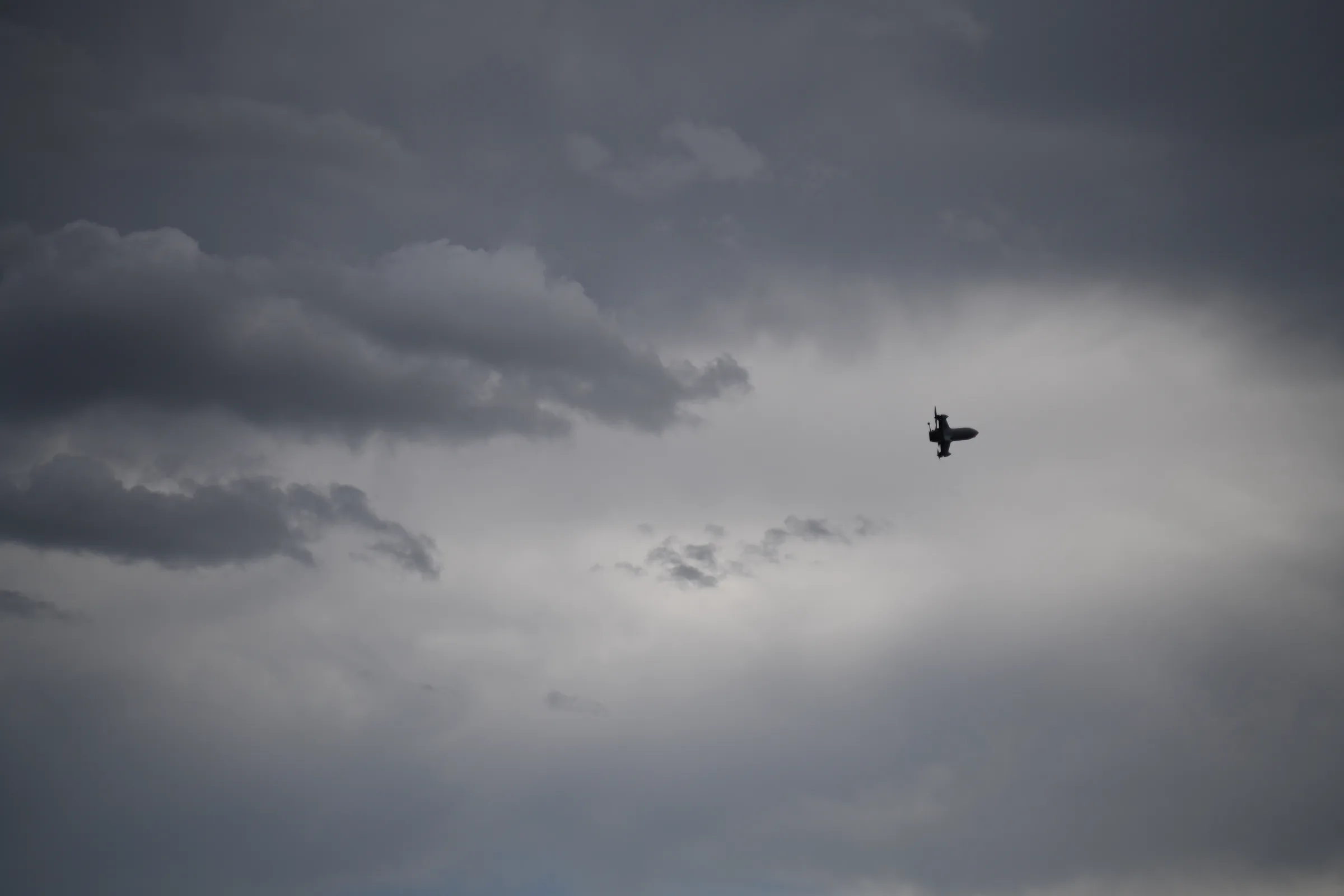 An Unmanned Industries UI Interceptor in flight, silhouetted against a cloudy sky